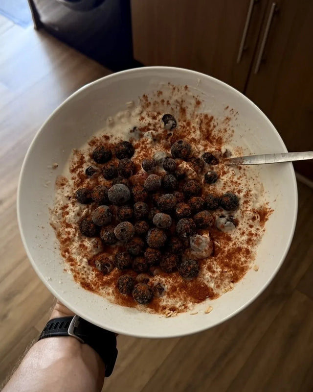 A bowl of oats topped with blueberries and cinnamon