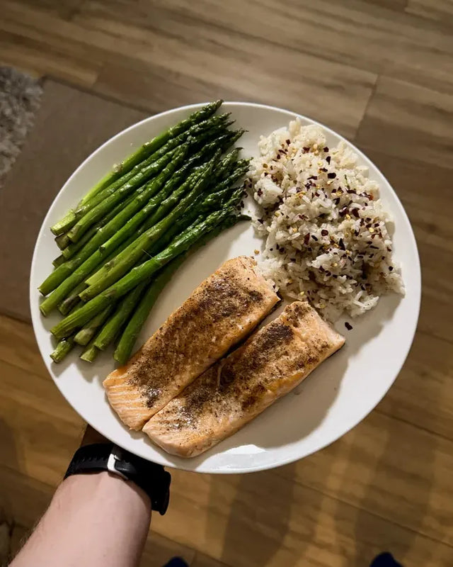 A plate with salmon, rice and asparagus